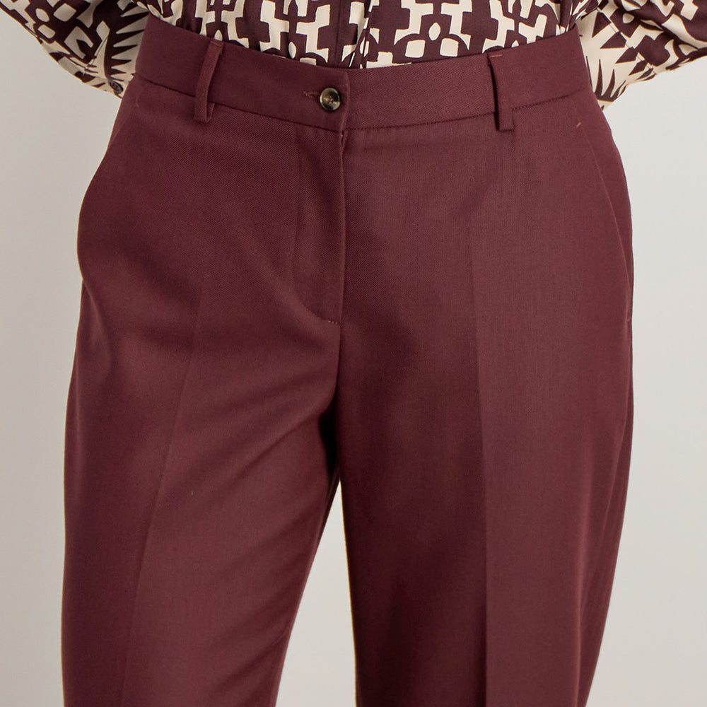 Détail du pantalon Raina bordeaux, fermeture zip avec bouton et finitions tailleur haut de gamme