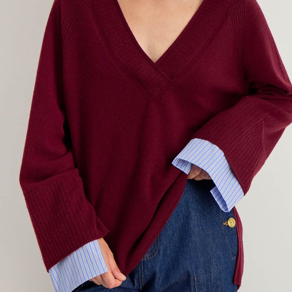 Détail du pull Lita : col V en maille douce et couture raglan, style faux layering