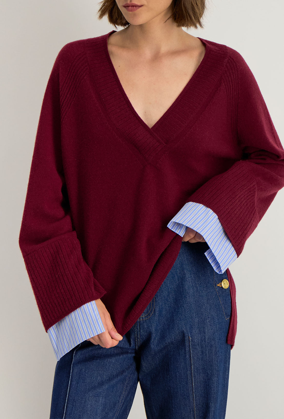 Détail du pull Lita : col V en maille douce et couture raglan, style faux layering