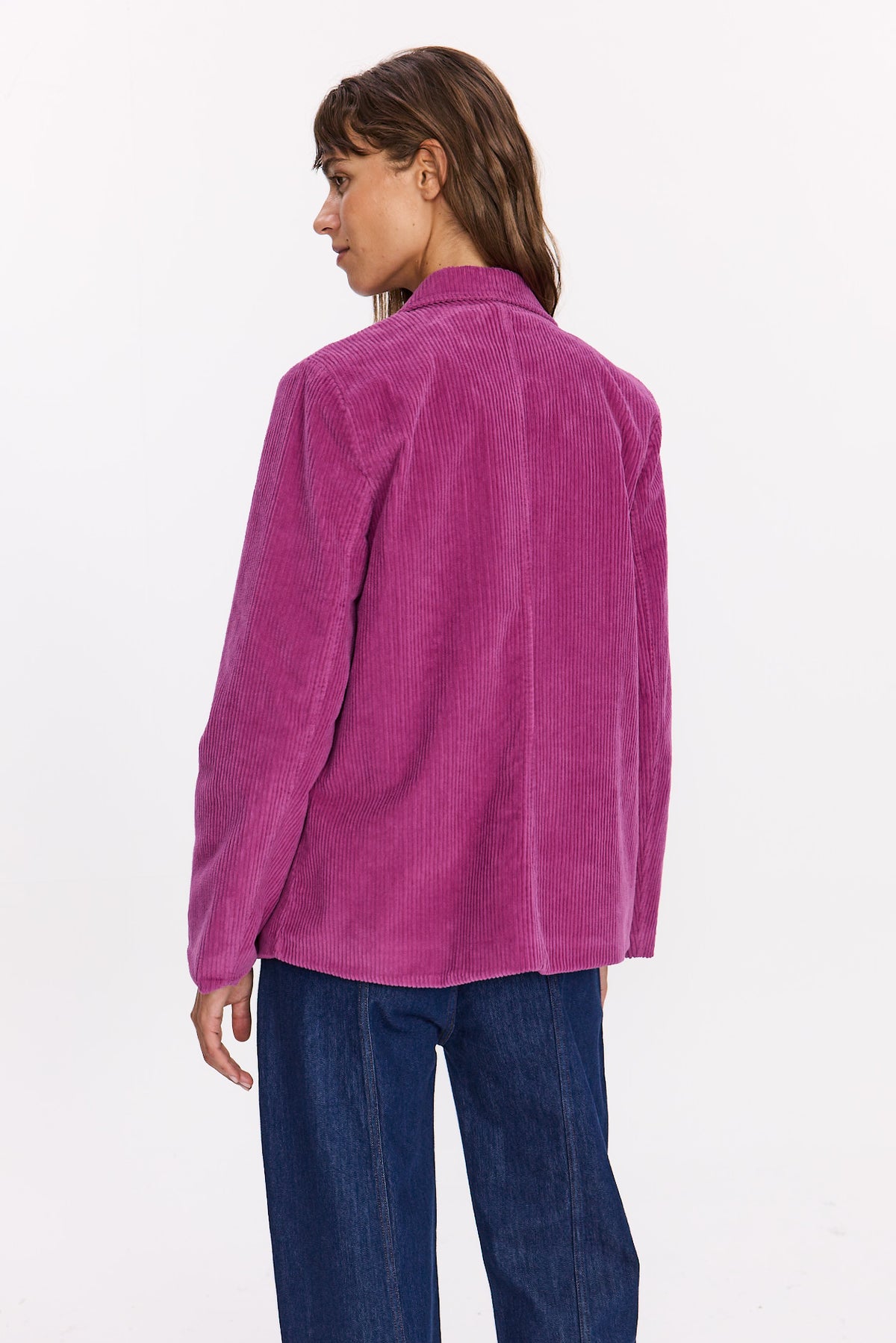 Veste Velvet fuchsia en velours côtelé vue de dos, portée avec un jean bleu.
