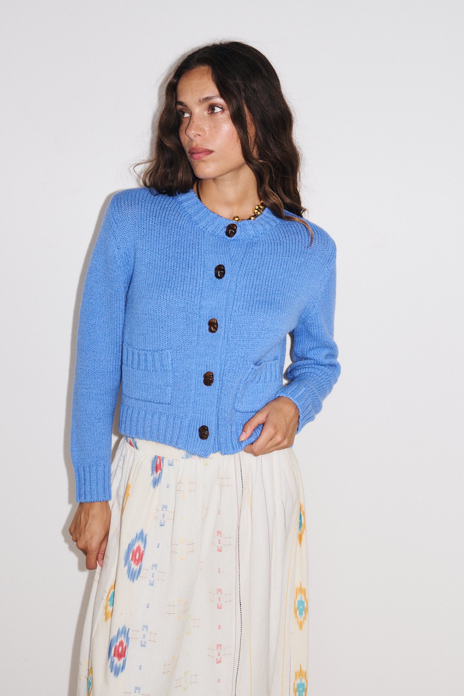 Zoom sur les détails du gilet Aza Stella Forest en maille douce coloris bleu clair, fermeture boutonnée et poches plaquées.