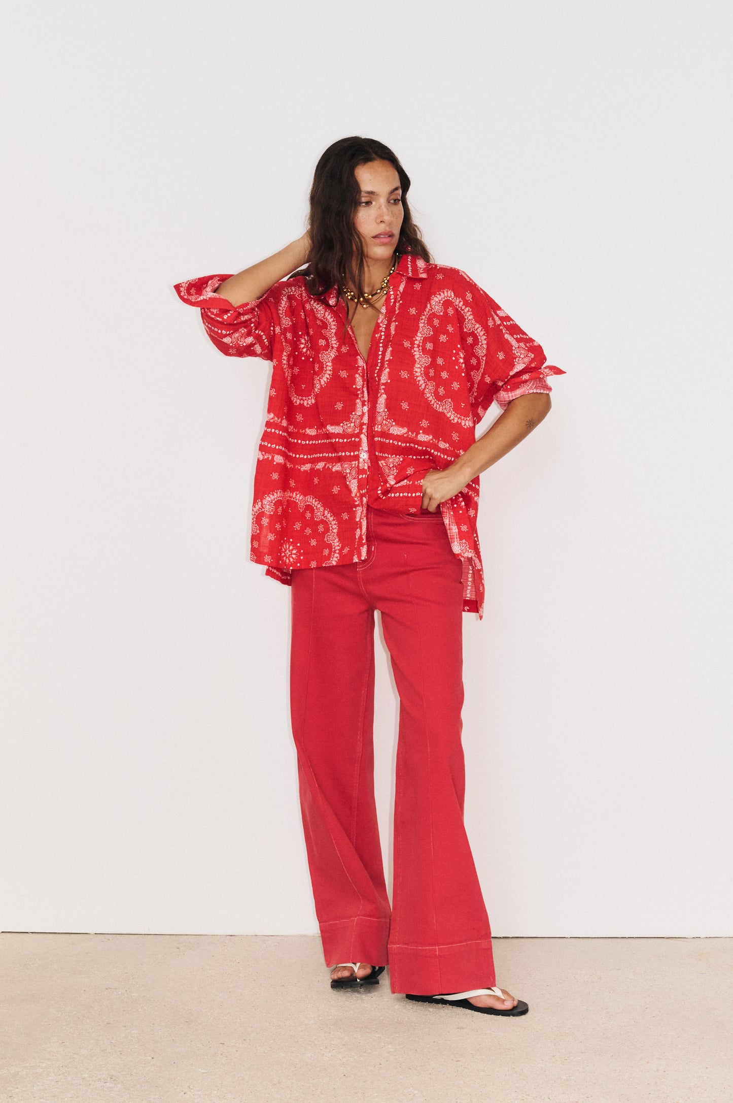 Détail du tombé fluide de la chemise en coton et viscose portée avec le pantalon Juliette rouge 

